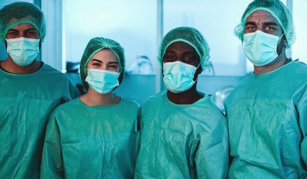 Medical workers inside hospital laboratory during coronavirus pandemic outbreak - Doctor and nurse at work on Covid-19 crisis period - Healthcare concept - Main focus on african man face